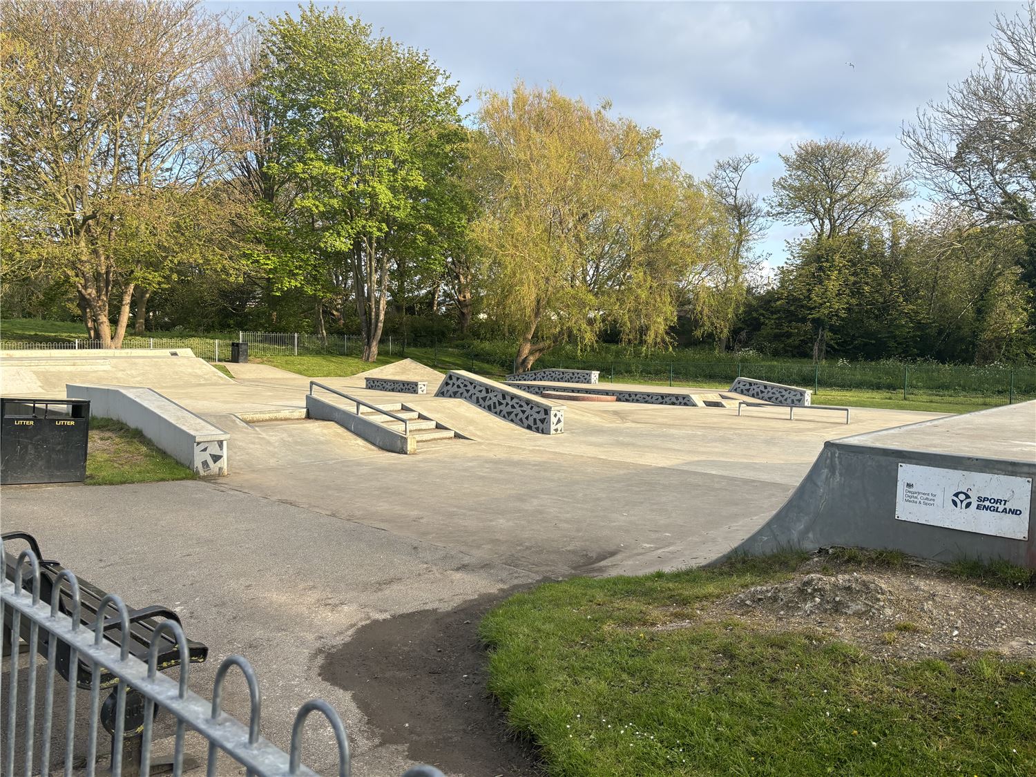 Image of Hornsea skate park which shows ramps in a fenced area made from concrete